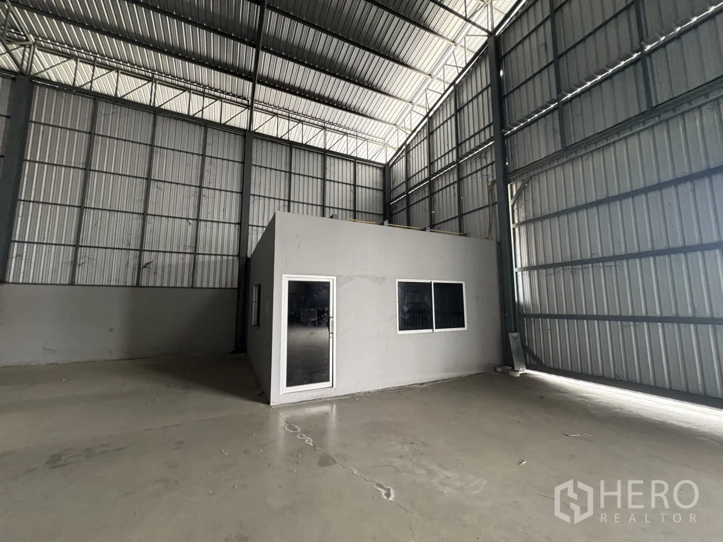 คลังสินค้า ให้เช่าในMueang Samut Prakan, Samut Prakan - ภาพใกล้ห้องสำนักงานภายในโกดัง พร้อมประตูและหน้าต่าง.