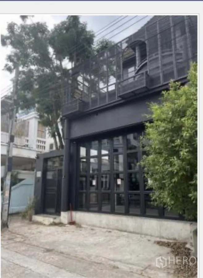 Home Office for rent in Wang Thonglang, Bangkok - Front facade showing tall grid windows and the street-side entrance.