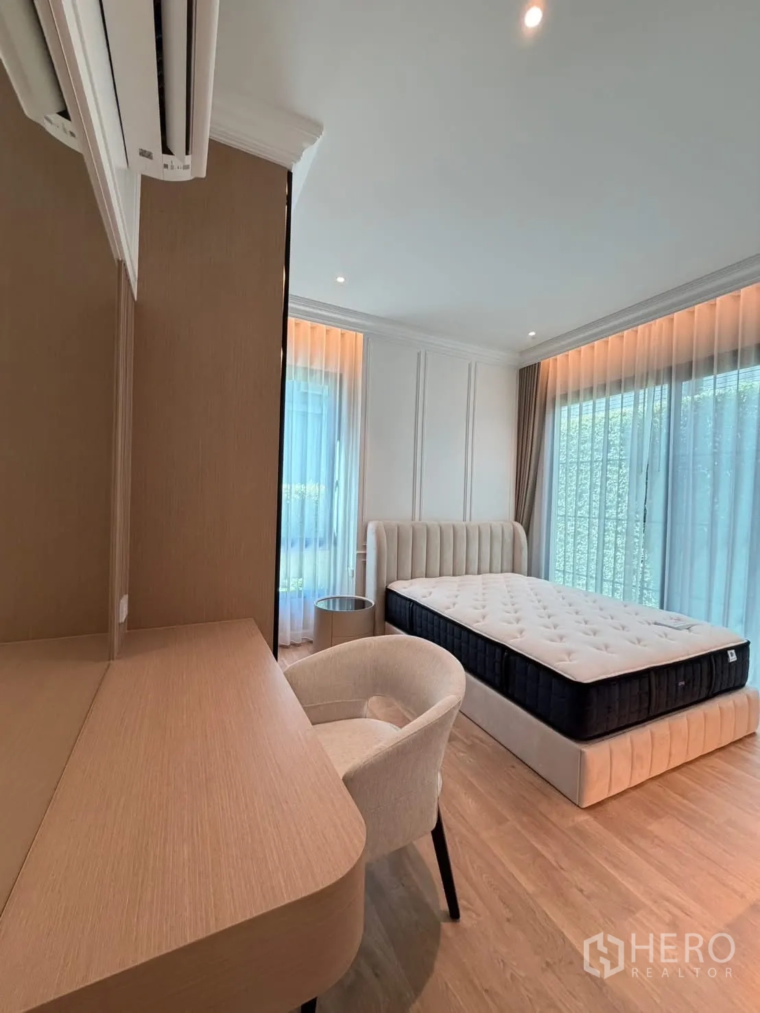Detached House for rent in Saphan Sung, Bangkok - Corner bedroom view with built-in desk, AC, and bed beside full-height windows.