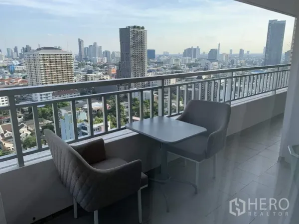Condominium for rent in Sathon, Bangkok - High-floor balcony with seating and panoramic Bangkok skyline view.
