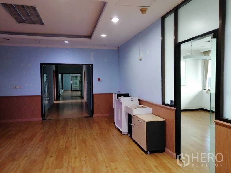 Office Space for rent in Bueng Kum, Bangkok - Open office zone with printers, recessed lighting, and glass‑framed rooms along the corridor.