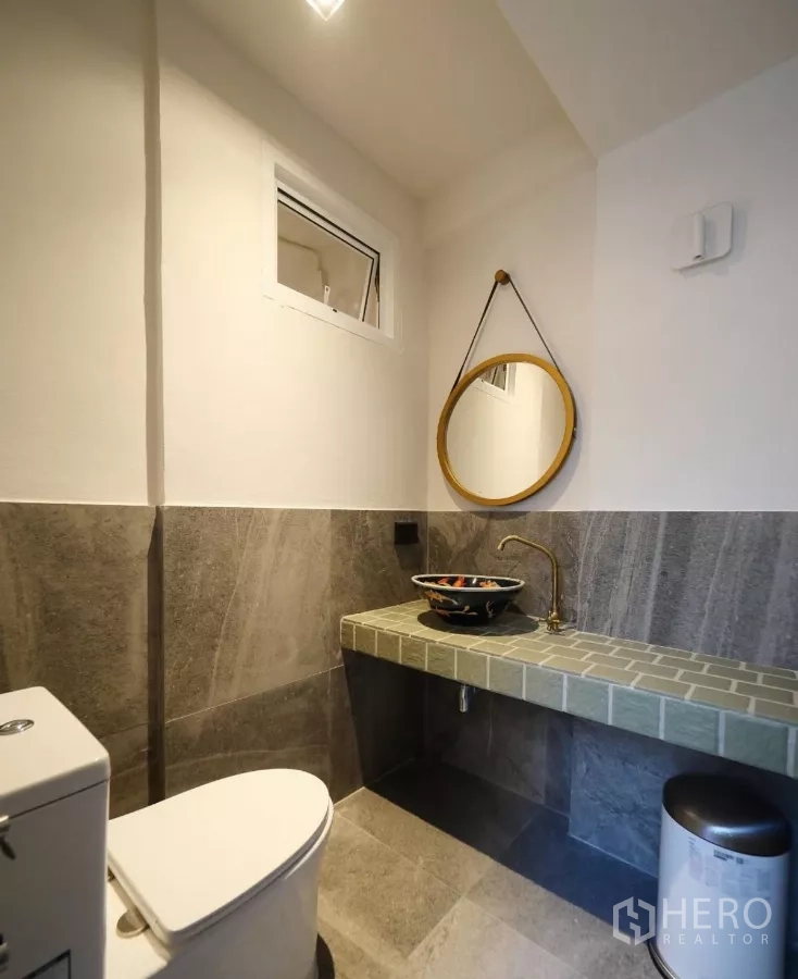 联排别墅 出租或出售在Watthana, Bangkok - 雅致盥洗室，圆形镜、台上盆与黄铜龙头。