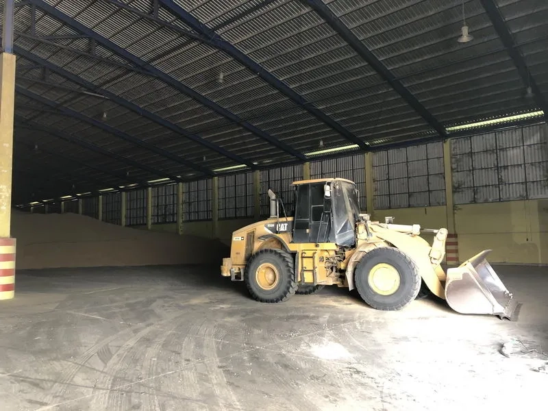 Warehouse for rent in Phra Nakhon Si Ayutthaya - High-clearance warehouse interior with a wheel loader parked on the concrete floor and ventilated side windows.