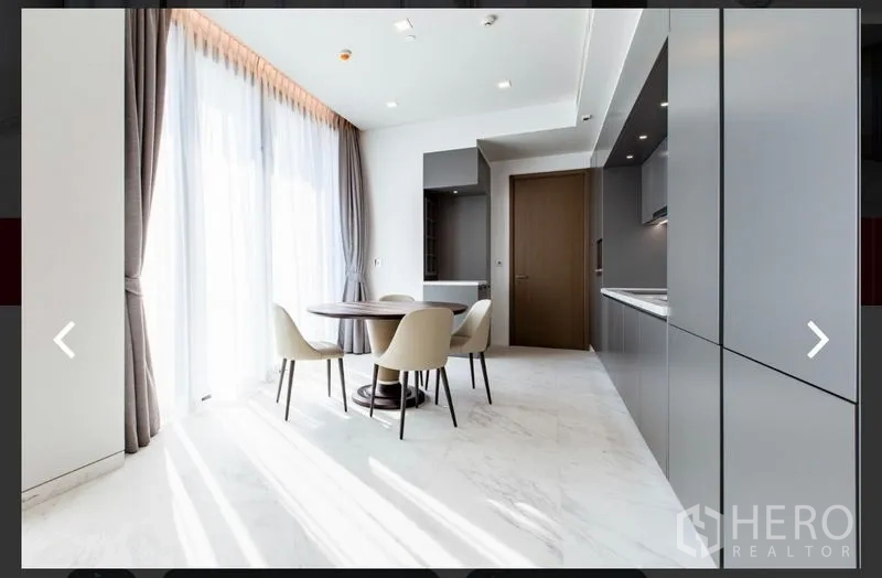 คอนโด ให้เช่าหรือขายในWatthana, Bangkok - มุมรับประทานอาหารริมหน้าต่างเต็มบาน ข้างครัวโมเดิร์นสีเทา