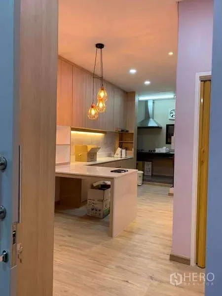 Townhouse for rent - Entry view into the kitchen with under-cabinet lighting, island workspace and stainless range hood at the rear.