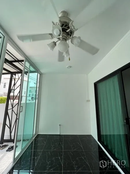 ทาวน์เฮาส์ ขายในBang Kapi, Bangkok - ซันรูมหน้าบ้านพร้อมพัดลมเพดาน พื้นกระเบื้องลายหินอ่อนดำ