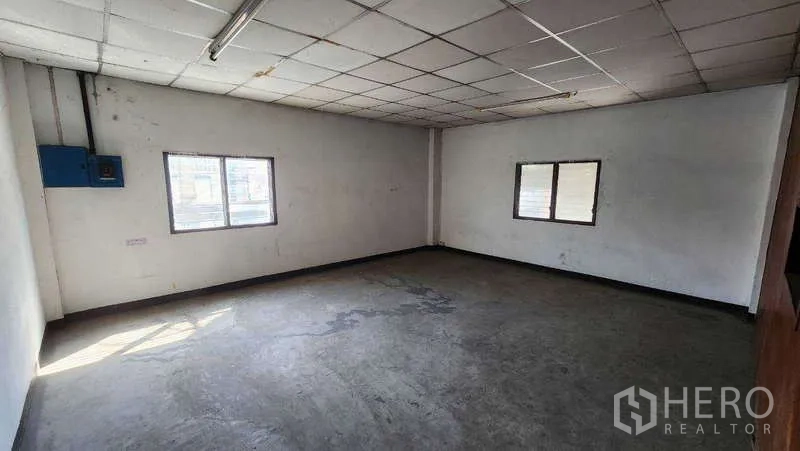 Warehouse for rent in Nong Khaem, Bangkok - Corner office with natural light and an electrical panel on the wall.