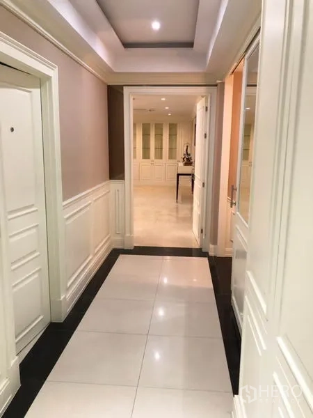 Shophouse for rent or sale in Chatuchak, Bangkok - Hallway with recessed ceiling opening to a bright lounge and built-in cabinets.