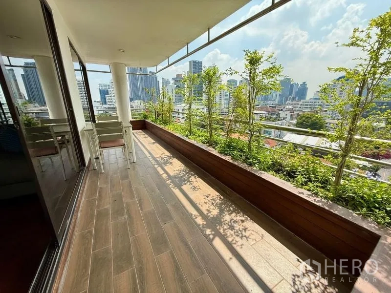Condominium for rent - Wide covered balcony with wood-look tiles, planter boxes, and skyline views.