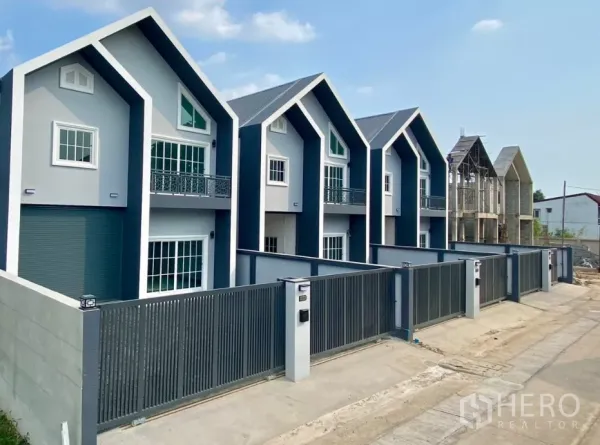 工厂 出租或出售在Bang Bua Thong, Nonthaburi - 多栋现代工厂单位一排分布，尖顶屋面与安全围栏。