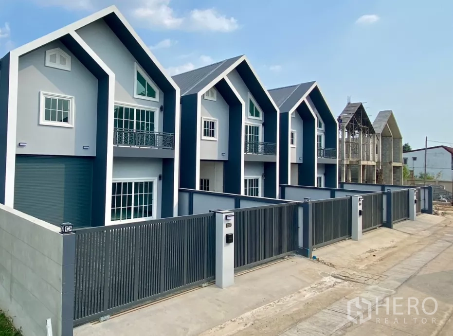 工厂 出租或出售在Bang Bua Thong, Nonthaburi - 多栋现代工厂单位一排分布，尖顶屋面与安全围栏。