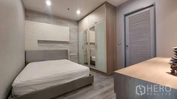 คอนโด ให้เช่าในWatthana, Bangkok - ห้องนอนพร้อมตู้เสื้อผ้าบิวท์อินบานกระจกและหัวเตียงสีเทาในคอนโดกรุงเทพฯ