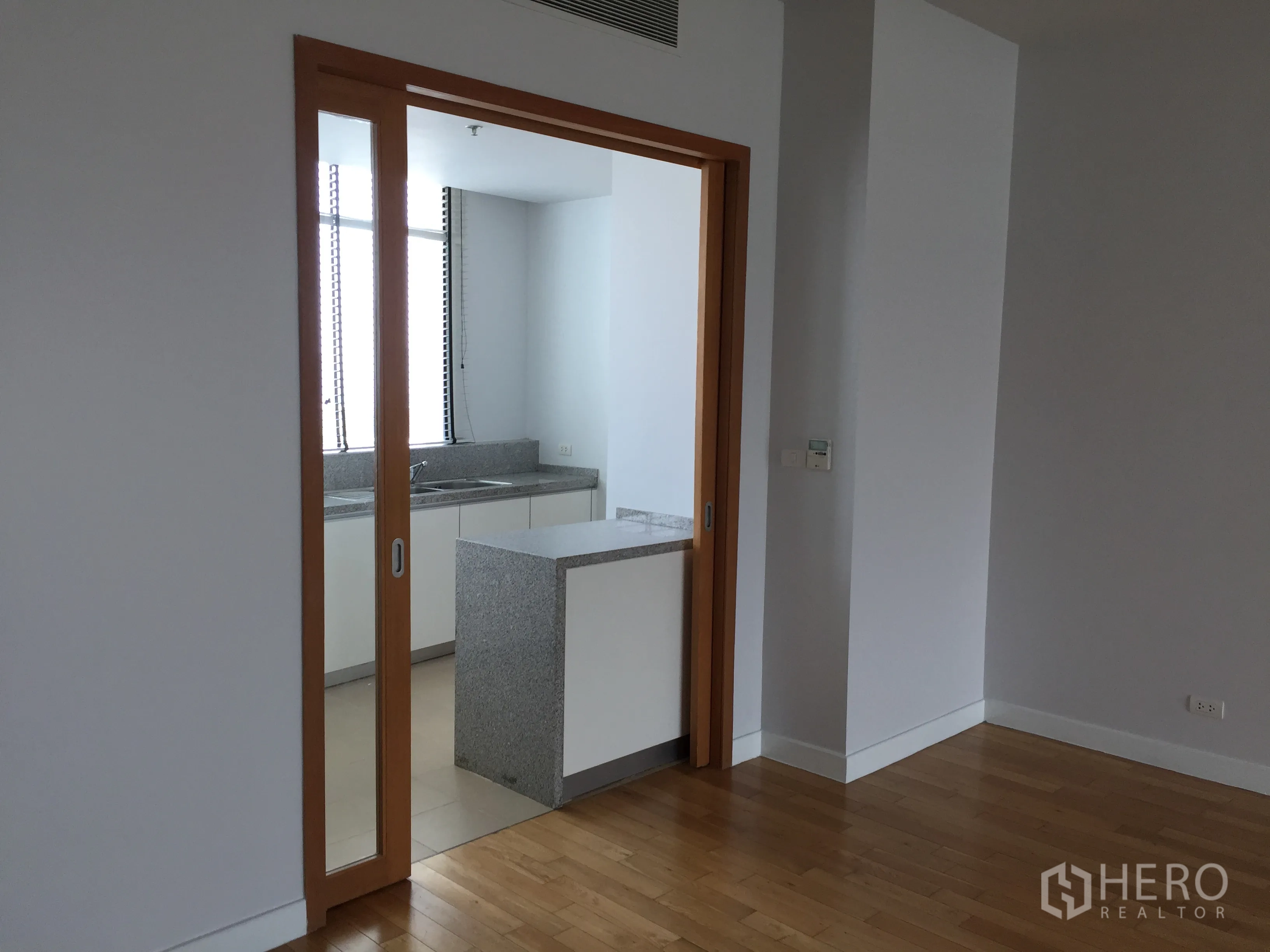 คอนโด ให้เช่าในKhlong Toei, Bangkok - ประตูบานเลื่อนกระจกเปิดสู่ครัวปิด เคาน์เตอร์หินแกรนิต.