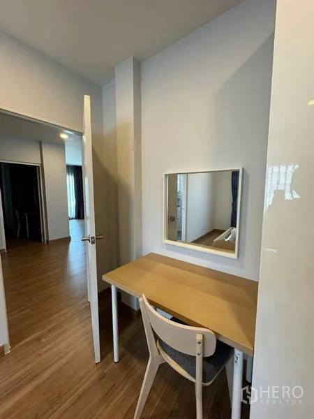 Detached House for rent in Don Mueang, Bangkok - Compact study corner with wooden desk, chair and wall mirror beside the bedroom.