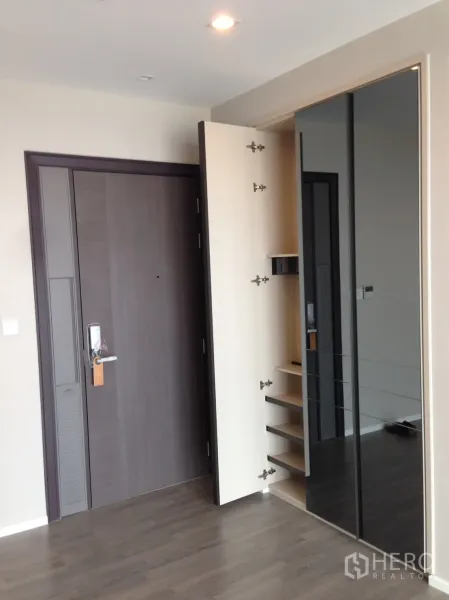 Condominium for rent in Bang Sue, Bangkok - Condo entry with dark wood door, built-in shoe cabinet and mirrored wardrobe.