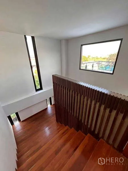 Home Office for rent or sale in Bang Phli, Samut Prakan - Stairwell with vertical slat balustrade and window overlooking the neighborhood.