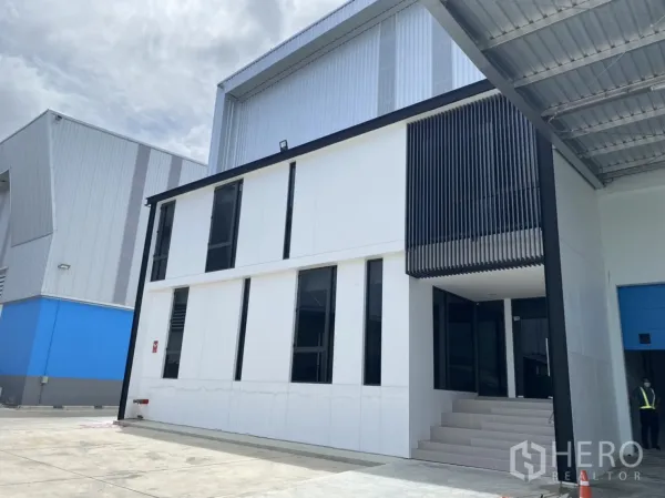 Warehouse for rent in Chachoengsao - Contemporary two‑storey office annex with louvered sunshade beside the warehouse.