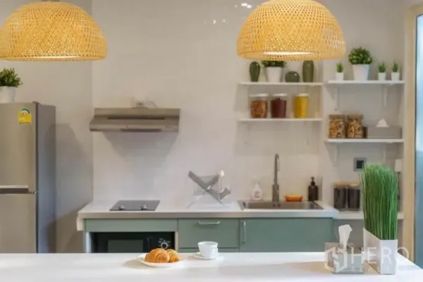 ทาวน์เฮาส์ ให้เช่าในKhlong Toei, Bangkok - ครัวมินิมอลพร้อมชั้นลอย เตาไฟฟ้า อ่างล้างจาน และโคมไฟหวาย