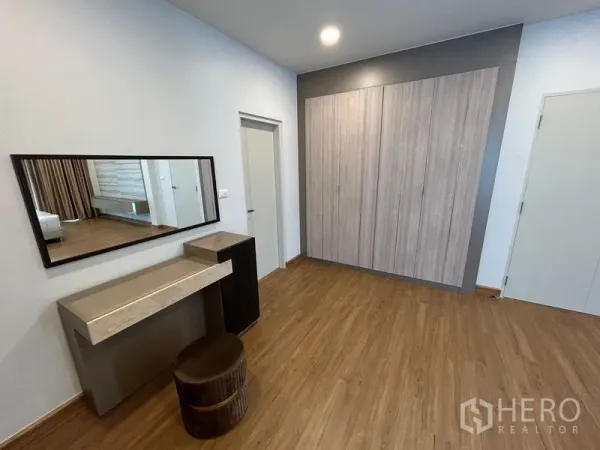 Detached House for rent in Bang Phli, Samut Prakan - Dressing area with long wall mirror, built-in wardrobes and wood flooring.