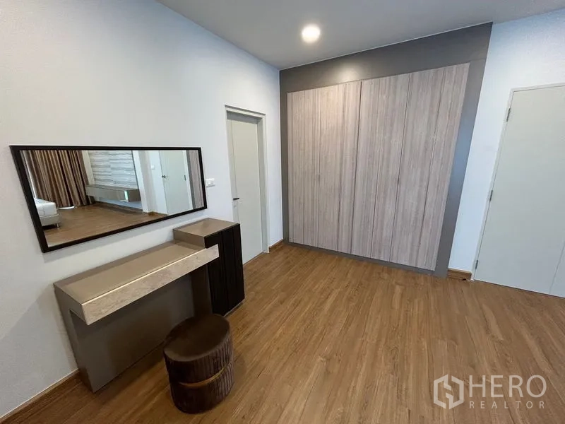 Detached House for rent in Bang Phli, Samut Prakan - Dressing area with long wall mirror, built-in wardrobes and wood flooring.