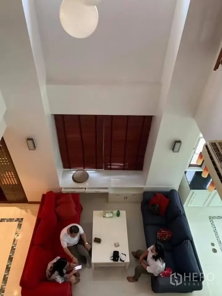 Townhouse for rent in Watthana, Bangkok - Double-height living area viewed from above with sofas and a coffee table.