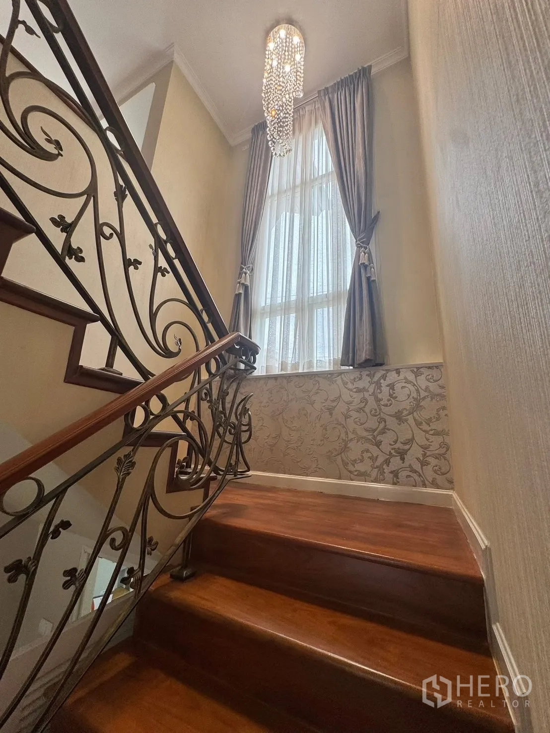 独立式住宅 出租在Prawet, Bangkok - 楼梯，雕花铁艺扶手、木阶与水晶吊灯。