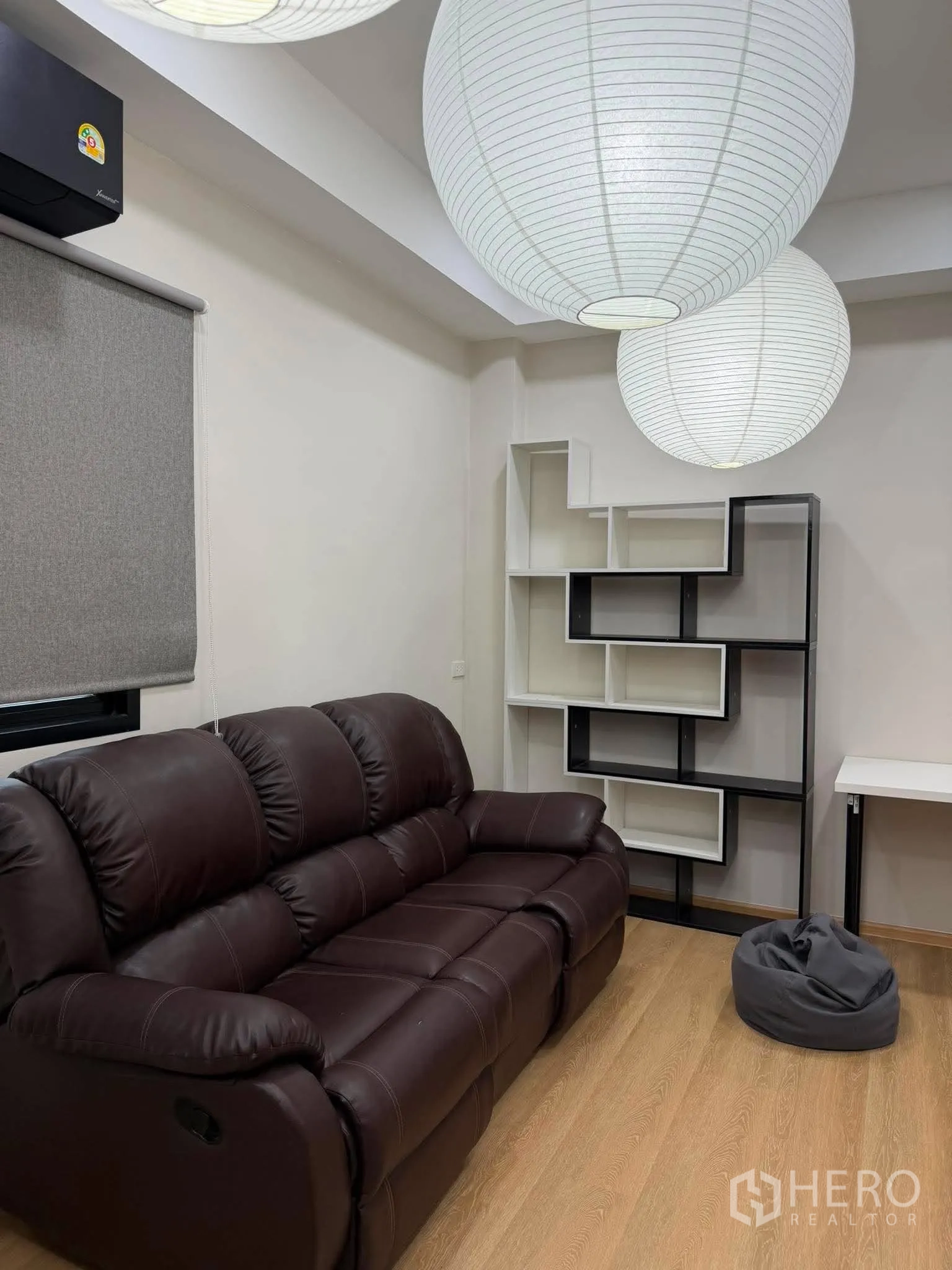 โฮมออฟฟิศ for rent in Phra Khanong, Bangkok - มุมนั่งเล่นพร้อมโซฟาหนังสีเข้มและชั้นวางโชว์