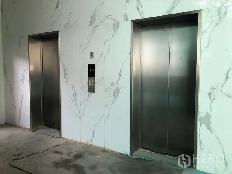 零售空间 出租在Min Buri, Bangkok - 大理石墙面电梯厅内的两部不锈钢客梯。