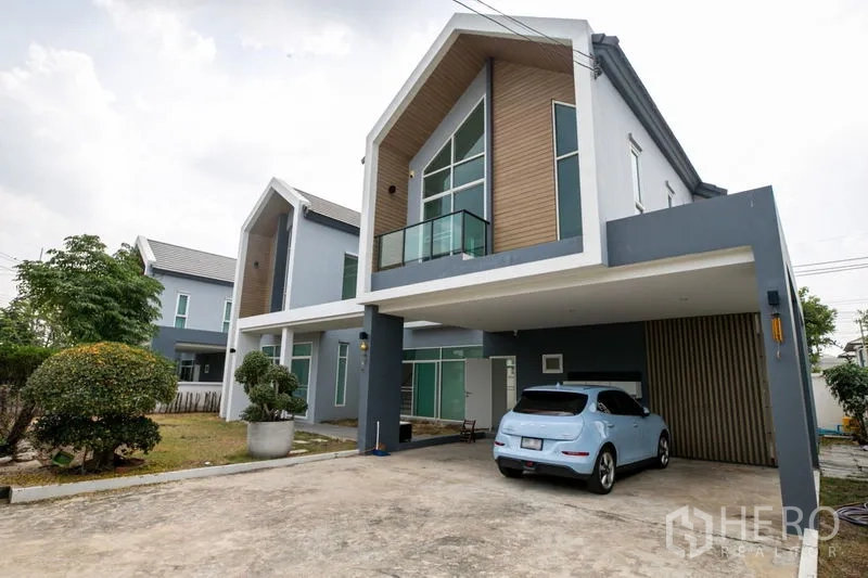 บ้าน ให้เช่าหรือขายในLam Luk Ka, Pathum Thani - ด้านหน้าบ้านมีที่จอดรถใต้อาคาร ระเบียง และผนังตกแต่งลายไม้