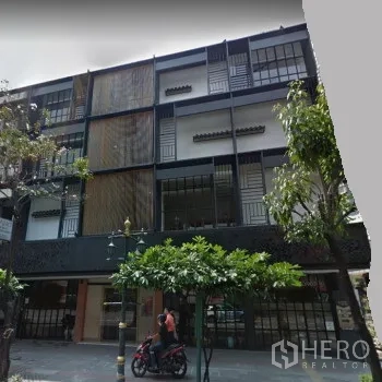 零售空间 出租在Khlong Toei, Bangkok - 通罗片区现代商业楼外立面，金属格栅与大面积玻璃。