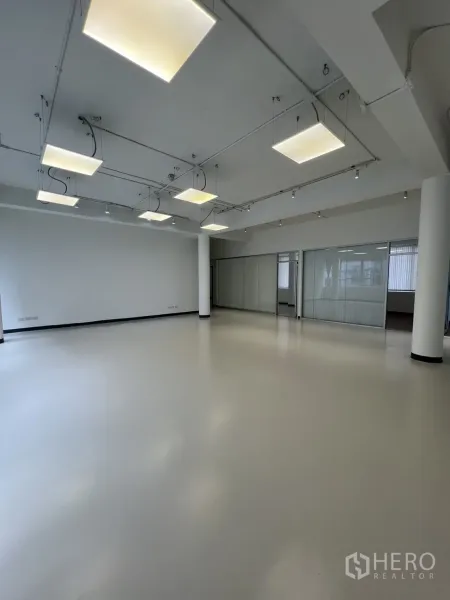 Office Space for rent in Bang Rak, Bangkok - Spacious open-plan workspace with suspended square lights and light floors.