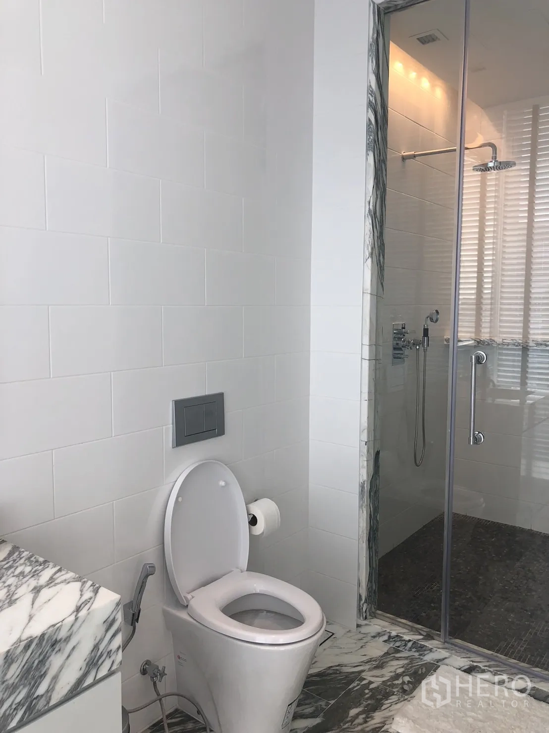 คอนโด ให้เช่าในBang Rak, Bangkok - ห้องน้ำแขกพร้อมห้องอาบน้ำกระจก ผนังกระเบื้องสีขาว และเคาน์เตอร์หินอ่อน