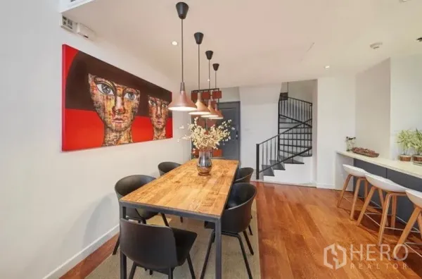 คอนโด ให้เช่าหรือขายในSathon, Bangkok - โซนรับประทานอาหาร โต๊ะไม้ยาว โคมแขวนสีทองแดง ภาพศิลปะ และบันไดวนสีดำ