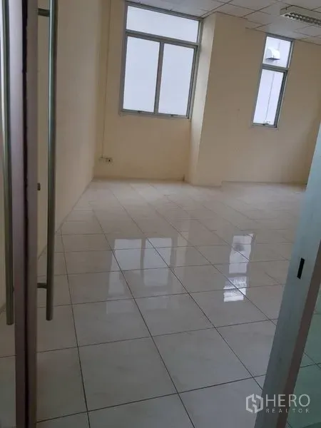 办公空间 出租在Phra Khanong, Bangkok - 空置办公室，光亮瓷砖地面、米色墙面，多扇窗户与玻璃入户门。