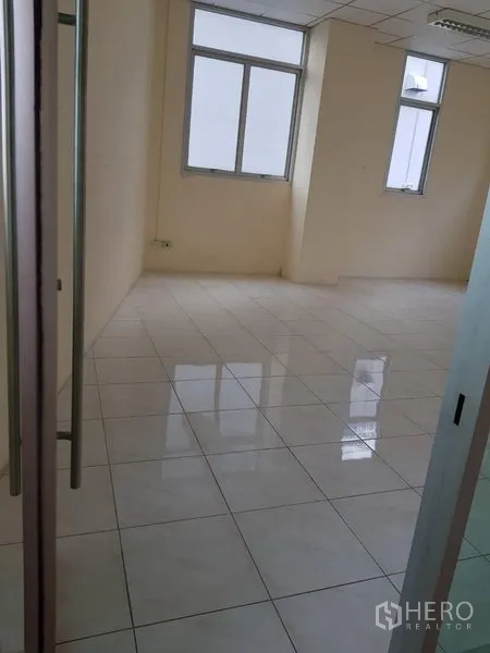 办公空间 出租在Phra Khanong, Bangkok - 空置办公室，光亮瓷砖地面、米色墙面，多扇窗户与玻璃入户门。