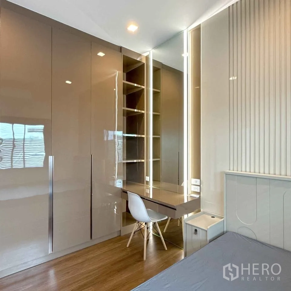 Detached House for rent in Bang Phli, Samut Prakan - Glossy floor-to-ceiling wardrobes beside a lit work desk with shelves.