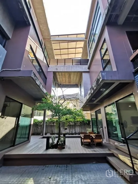 Home Office for sale in Wang Thonglang, Bangkok - Courtyard view upward showing bridges, balconies and outdoor seating area.