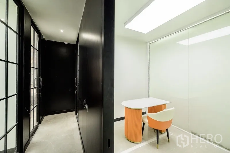 办公空间 出租或出售在Huai Khwang, Bangkok - 紧凑会谈室，玻璃墙连接深色走廊。