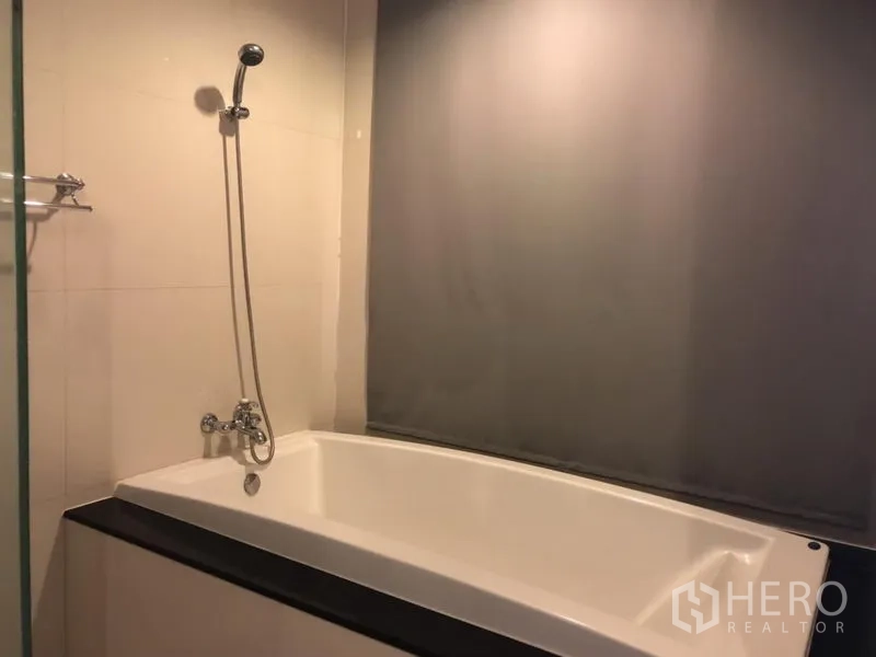 คอนโด ให้เช่าในPathum Wan, Bangkok - ห้องน้ำพร้อมอ่างอาบน้ำบิวท์อินและฝักบัวแบบสาย บนผนังกระเบื้อง