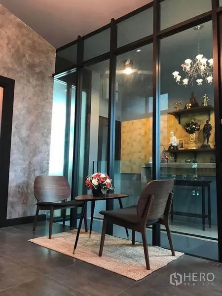 Office Space for rent in Bang Kapi, Bangkok - Waiting nook with two chairs and small table beside a glass partition and chandelier view.