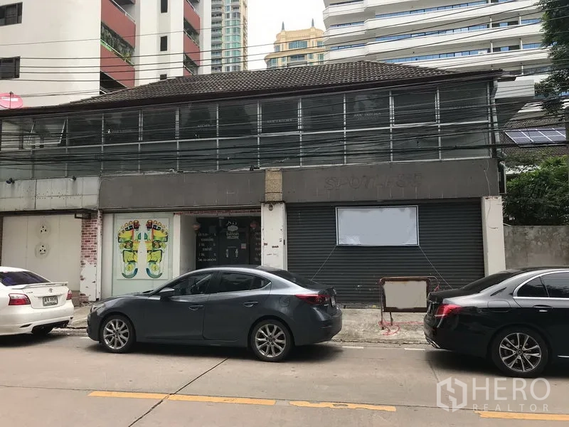 พื้นที่ขายปลีก ให้เช่าในWatthana, Bangkok - อาคารพาณิชย์สองชั้นด้านหน้าแบบโรลเลอร์ชัตเตอร์ ประตูกระจก และที่จอดรถหน้าร้านย่านสุขุมวิท