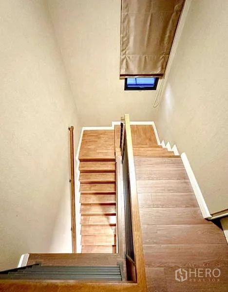 Detached House for sale in Bang Phli, Samut Prakan - Wood staircase with handrail and high ceiling window bringing in natural light.