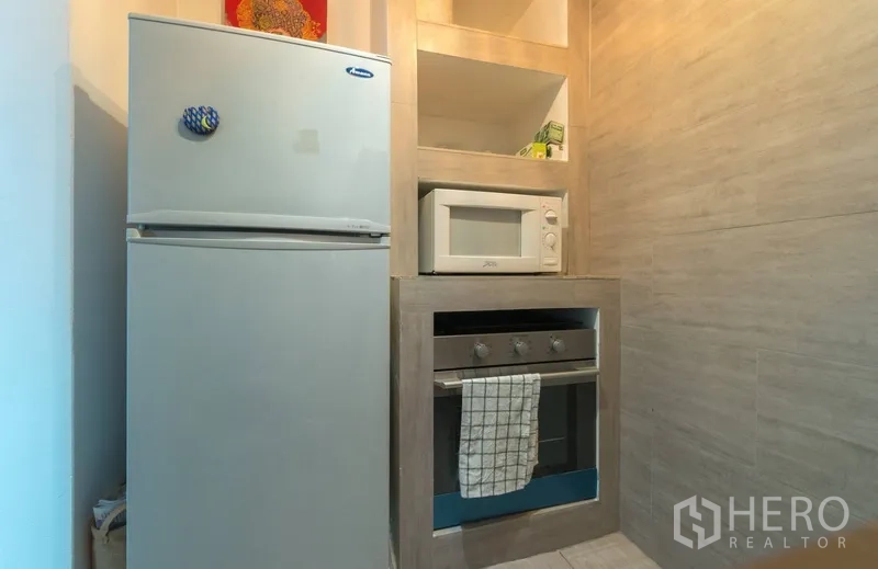 Condominium for rent in Pathum Wan, Bangkok - Compact kitchen with refrigerator, built-in oven and microwave.