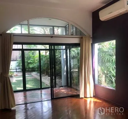 บ้าน ให้เช่าในBang Rak, Bangkok - ห้องสว่างด้วยประตูกระจกบานเลื่อนเปิดออกสู่สวน พร้อมเครื่องปรับอากาศติดผนัง