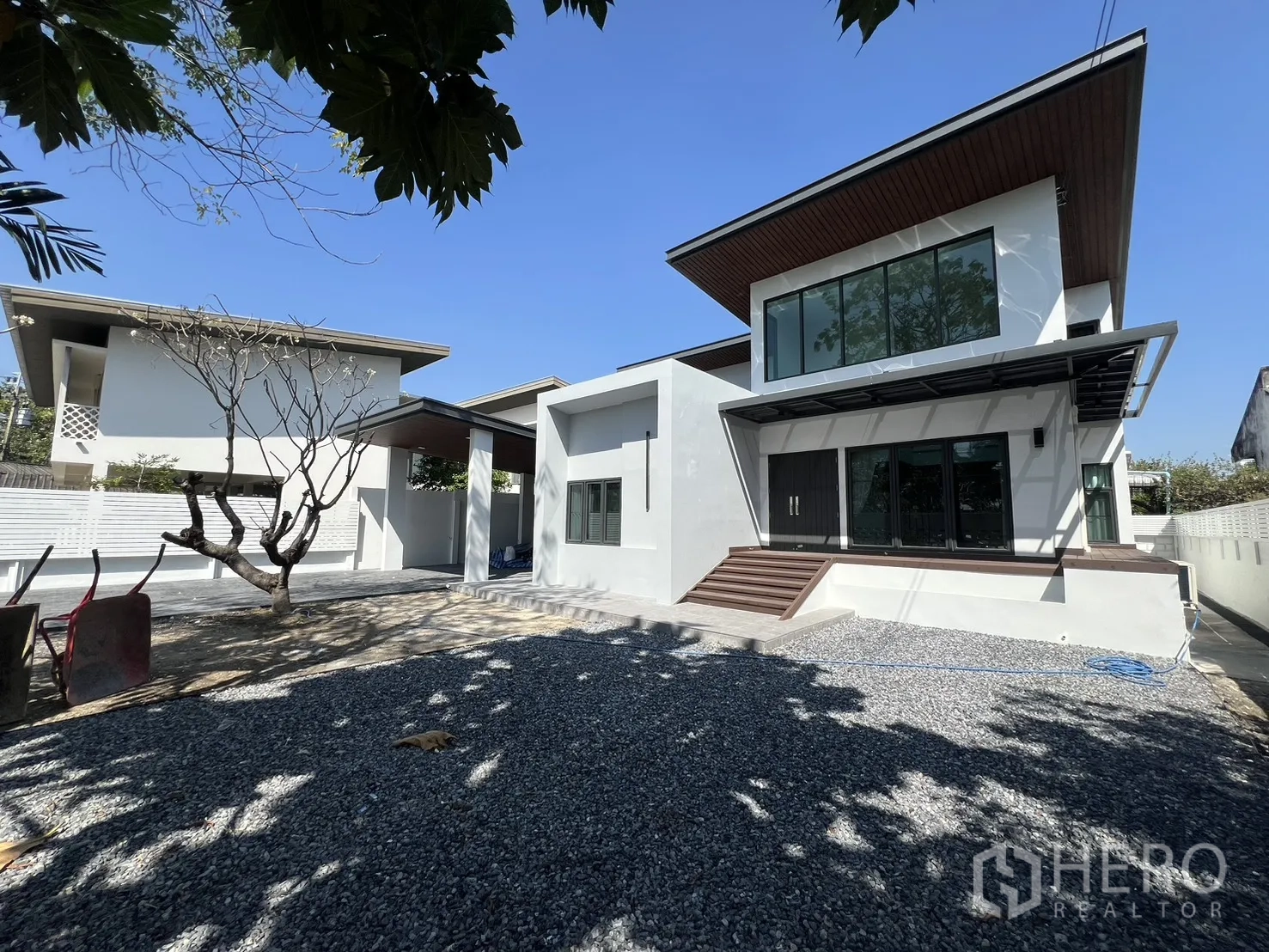 บ้าน ให้เช่าในSaphan Sung, Bangkok - บ้านเดี่ยวสไตล์โมเดิร์นสีขาว พร้อมลานกรวดและสนามกว้างใต้ท้องฟ้าแจ่มใส