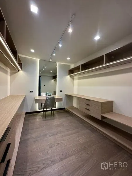 Detached House for rent in Suan Luang, Bangkok - Large walk-in closet with built-in shelving, dressing table and wood flooring.