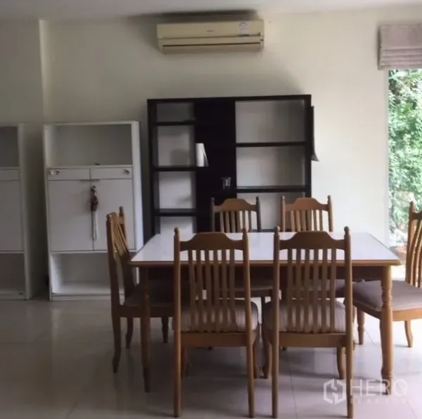 Detached House for rent in Bang Phli, Samut Prakan - Bright dining area with six-seat wooden table, shelving units and large windows.