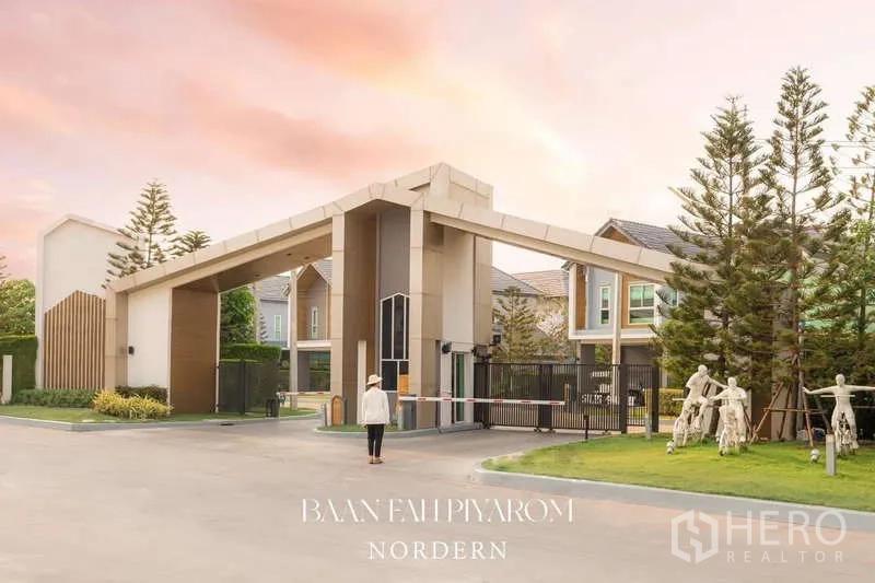 บ้าน ขายในLam Luk Ka, Pathum Thani - ซุ้มทางเข้าโครงการที่มีระบบรักษาความปลอดภัย รายล้อมด้วยต้นไม้ใหญ่