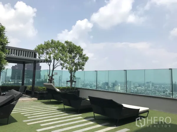 公寓 出租或出售在Sathon, Bangkok - 空中花园休闲区，躺椅与绿植，玻璃护栏面向曼谷全景。