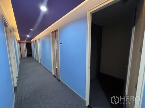 零售空间 出租在Bang Rak, Bangkok - 第二条走廊，蓝色墙面与多扇房门连接服务间。